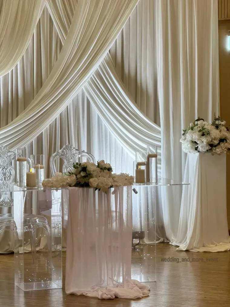 Hochzeitsbühne mit weißer Draperie und Brauttisch