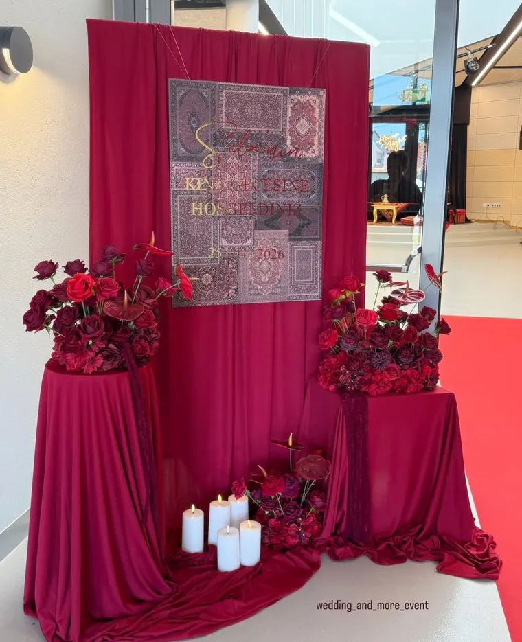 Festsaal mit bordeauxroter Draperie und weißen Stühlen