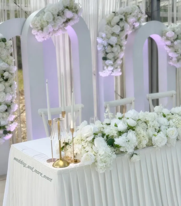 Romantischer weißer Blumenbogen mit Kerzen
